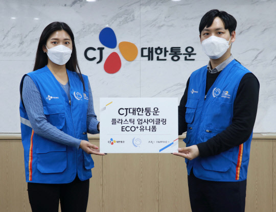 CJ대한통운 직원이폐플라스틱 업사이클링 통해 제작한 'ECO+ 유니폼'을 입고 기념 촬영하고 있다. <CJ대한통운 제공>